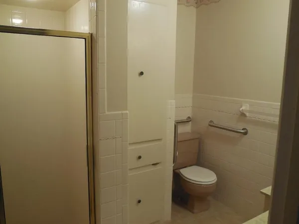 a white toilet sitting next to a shower