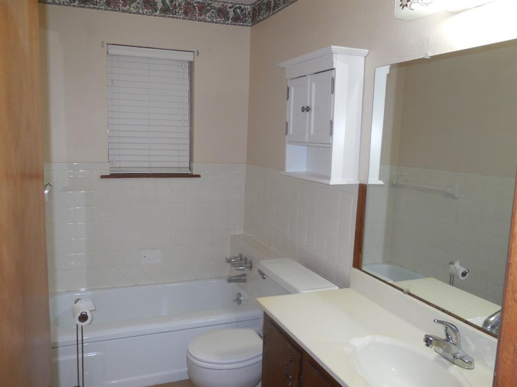 820 Walnut Street Ranger, TX 76470 - Photo 18 of 21 a bathroom with a sink a toilet and shower