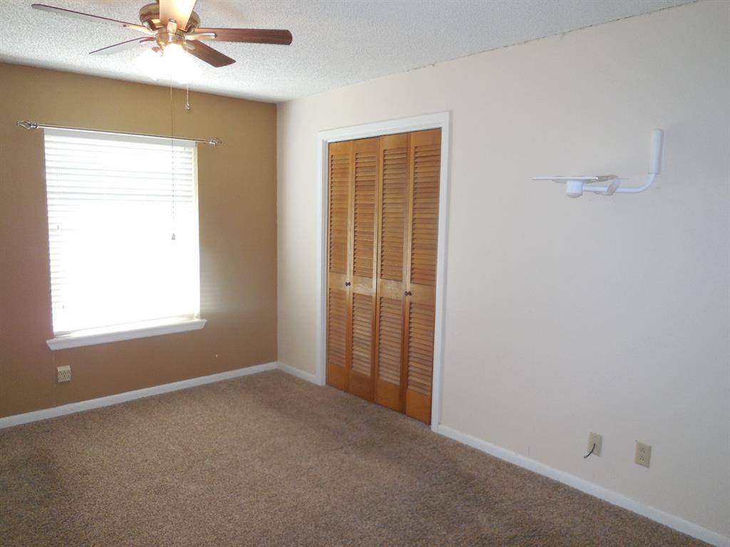 820 Walnut Street Ranger, TX 76470 - Photo 5 of 21 an empty room with a window and a fan
