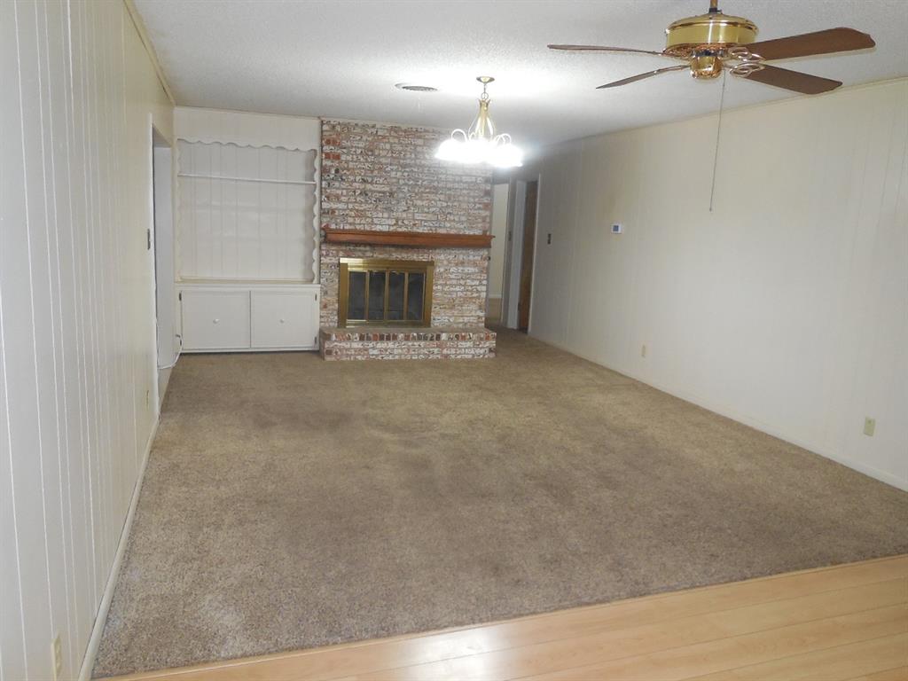 820 Walnut Street Ranger, TX 76470 - Photo 8 of 21 an empty room with windows and fireplace