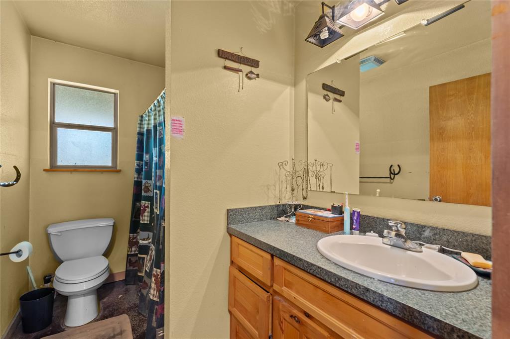 262 North Cheyenne Springtown, TX 76082 - Photo 14 of 35 Bathroom featuring a shower with shower curtain, vanity, and a textured wall