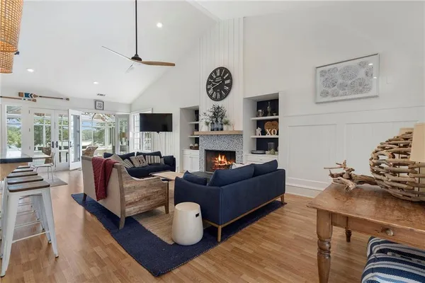 a living room with furniture kitchen view and a chandelier