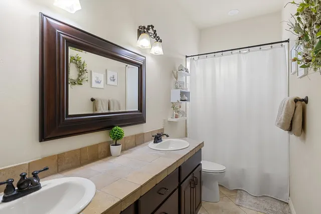 a bathroom with a sink vanity mirror and toilet
