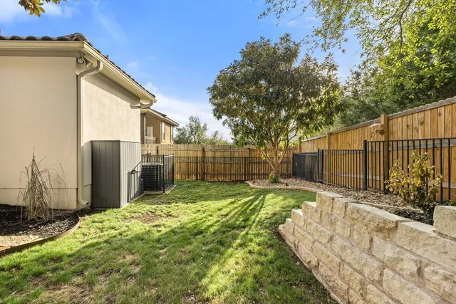 a view of backyard with wooden fence