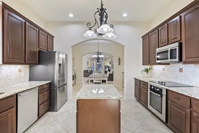 a kitchen with stainless steel appliances granite countertop a sink stove and refrigerator