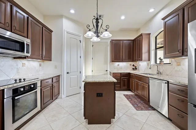 a kitchen with stainless steel appliances granite countertop a sink stove and microwave