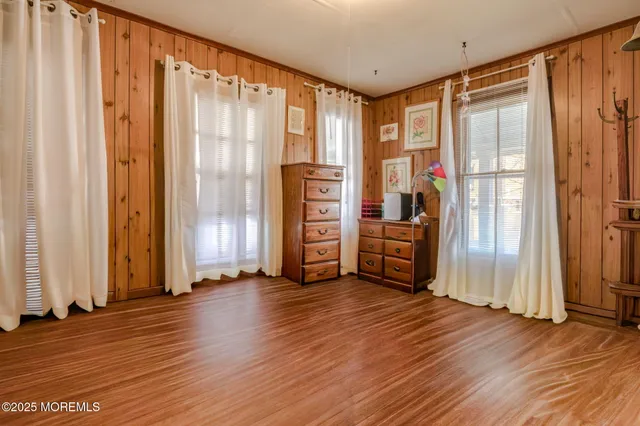 a bedroom with a bed next to a window and a flat screen tv