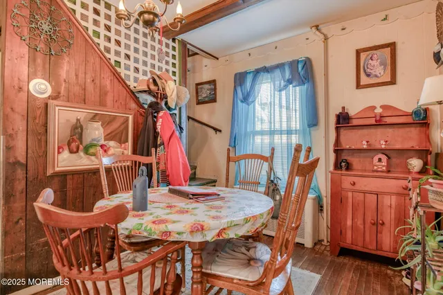 a kitchen with stainless steel appliances granite countertop a refrigerator a stove a sink a dining table and chairs with wooden floor