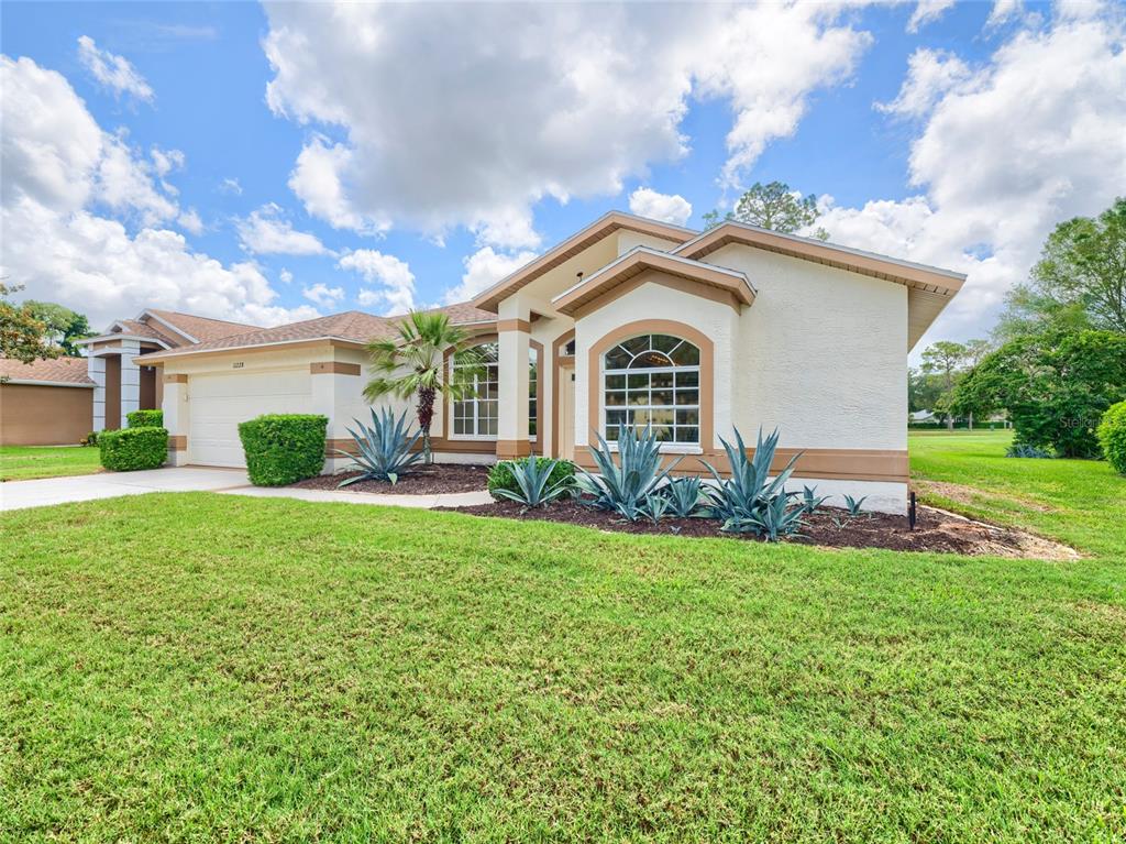 11228 Windrush Circle Hudson, FL 34667 - Photo 44 of 67 a front view of a house with a yard