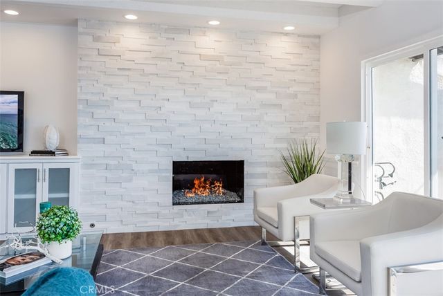 a living room with fireplace furniture and a potted plant