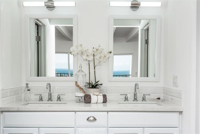 a bathroom with double vanity sinks and a mirror