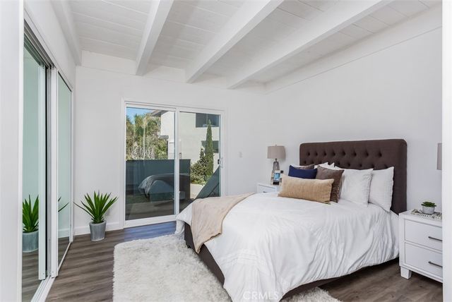a bedroom with a large bed and a potted plant