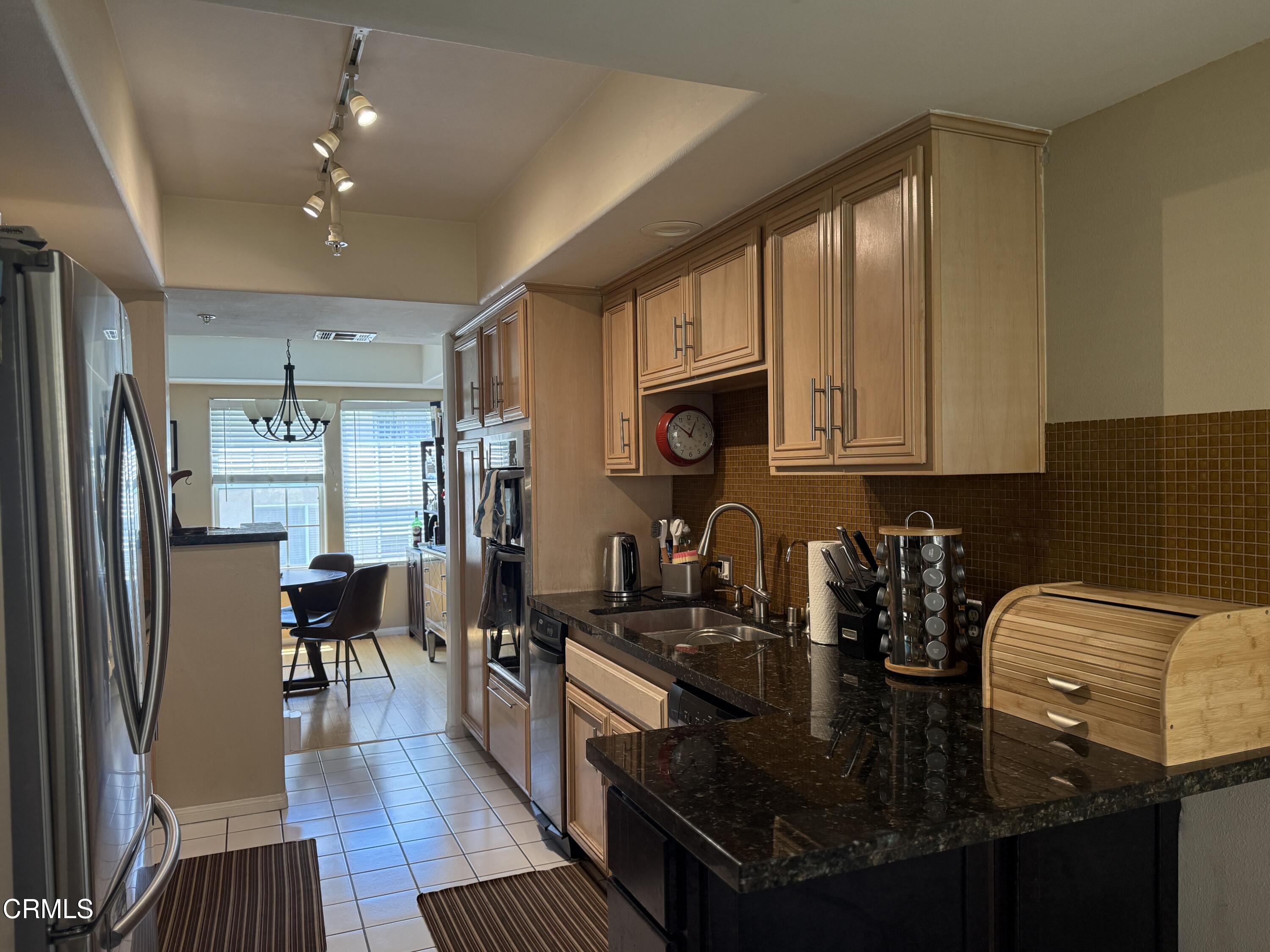 4259 Fulton Avenue, Unit 307 Sherman Oaks, CA 91423 - Photo 4 of 17 a kitchen with counter top space cabinets and stainless steel appliances