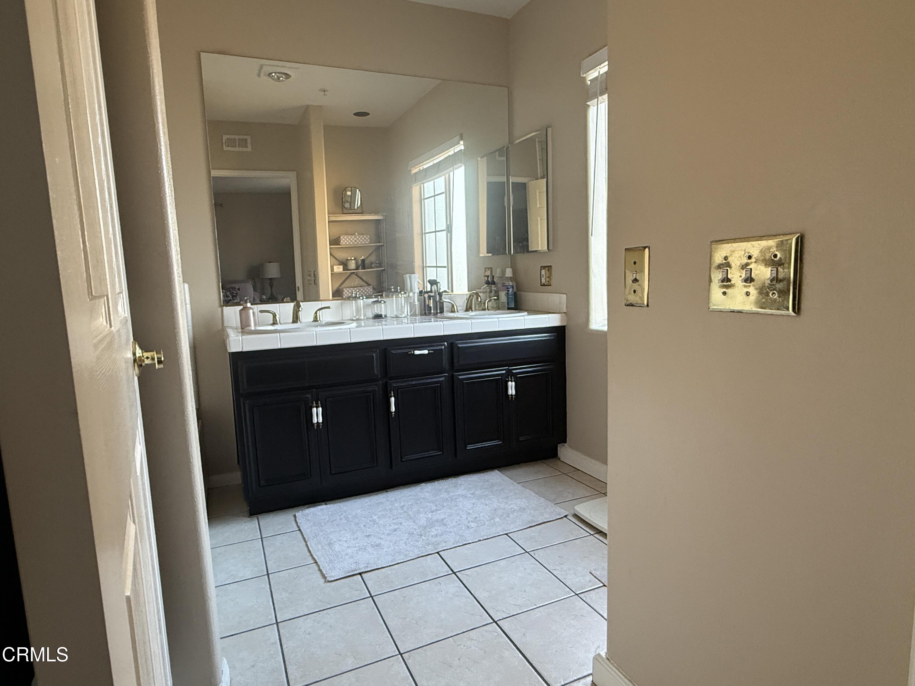 4259 Fulton Avenue, Unit 307 Sherman Oaks, CA 91423 - Photo 8 of 17 a spacious bathroom with a vanity a sink a mirror and a shower