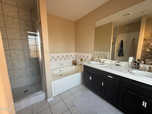 a bathroom with a tub sink shower and mirror