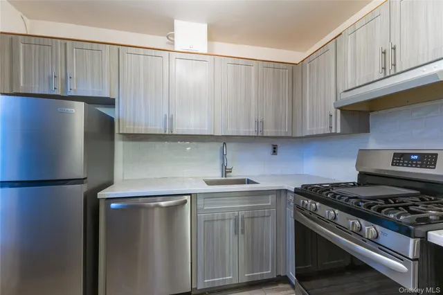 a kitchen with stainless steel appliances granite countertop a stove a refrigerator and a cabinets