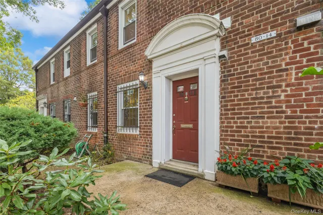 a view of a brick house with potted plants