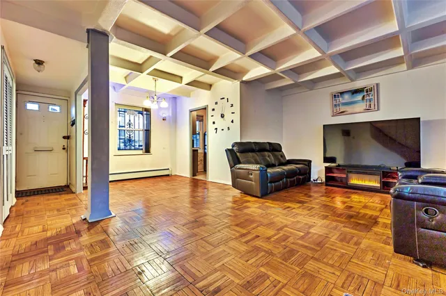 a living room with furniture a flat screen tv and kitchen view