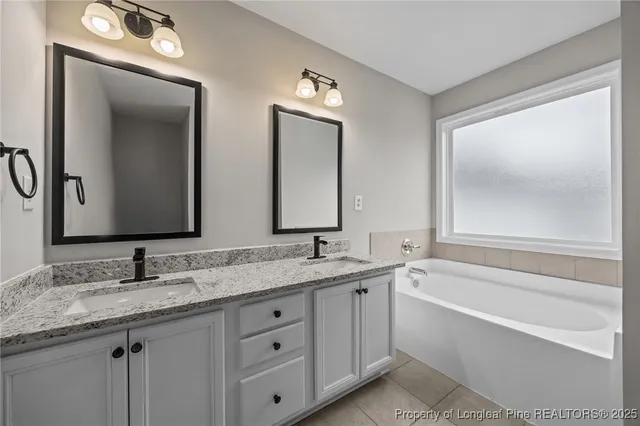 a bathroom with double vanity sinks and a mirror