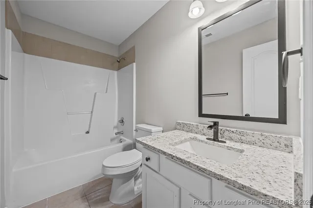a bathroom with a granite countertop sink a toilet and a large mirror