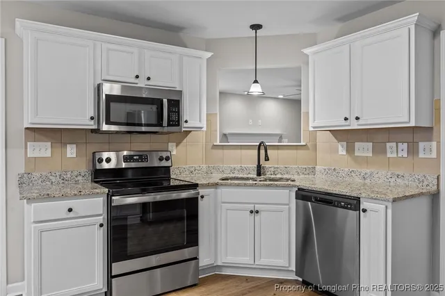 a kitchen with stainless steel appliances granite countertop a stove a sink and a microwave