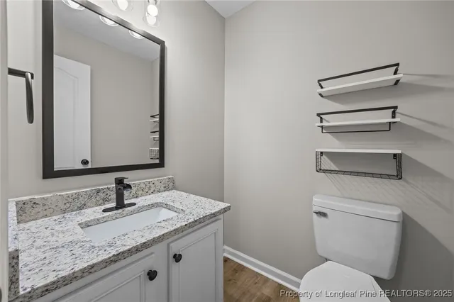 a bathroom with a granite countertop toilet sink and mirror
