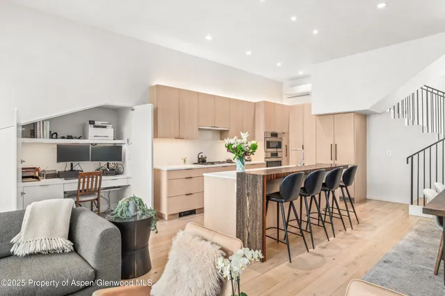 a kitchen with stainless steel appliances kitchen island granite countertop a sink a stove a dining table and chairs