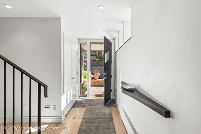 a view of a hallway with wooden floor and staircase