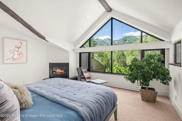 a bed sitting in a spacious bedroom next to a window