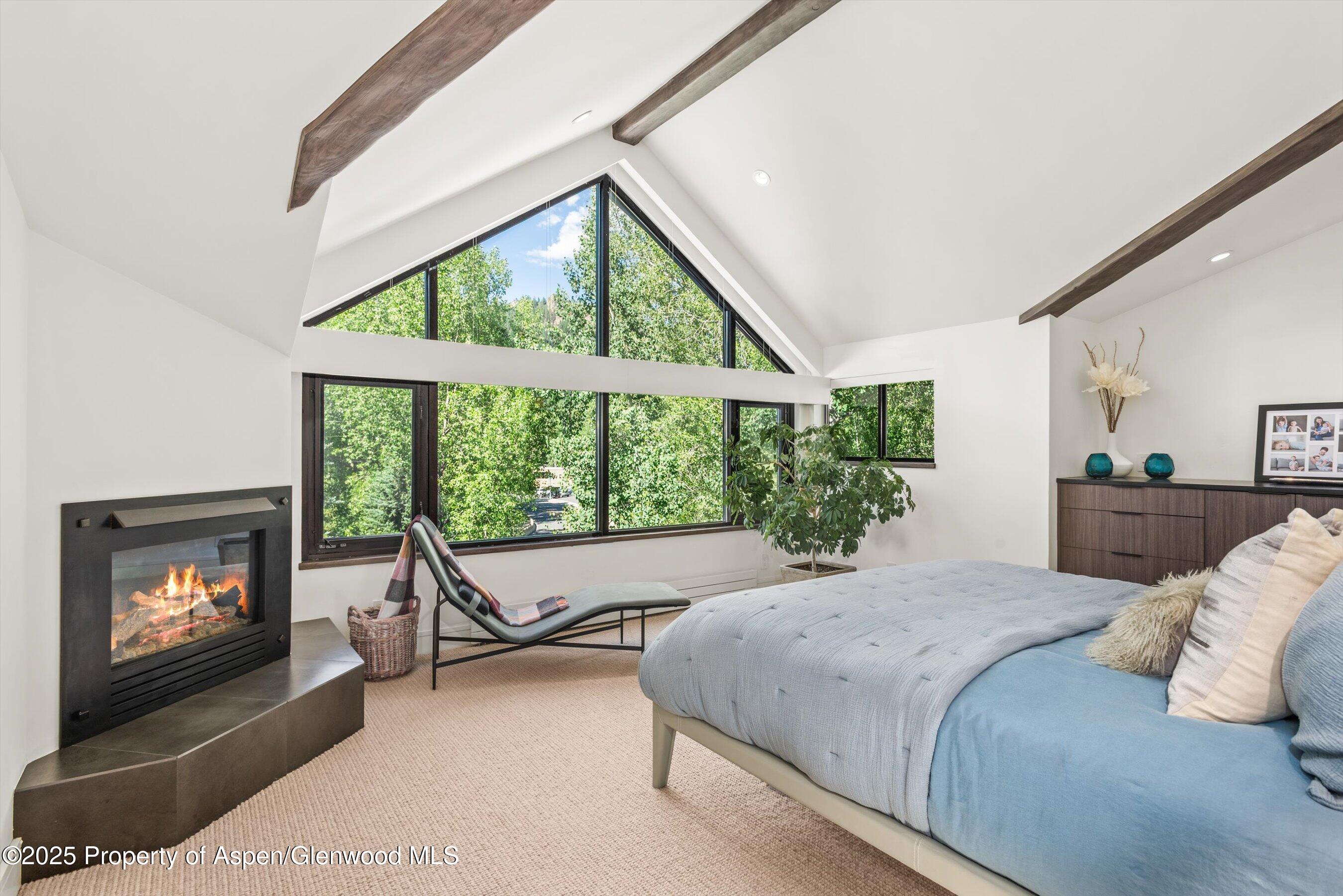 155 Lone Pine Road, Unit RIVER BLUFF #2 Aspen, CO 81611 - Photo 24 of 42 a bedroom with a bed and a fireplace