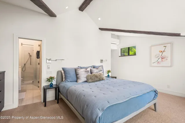 a bedroom with a large bed and painting on the wall