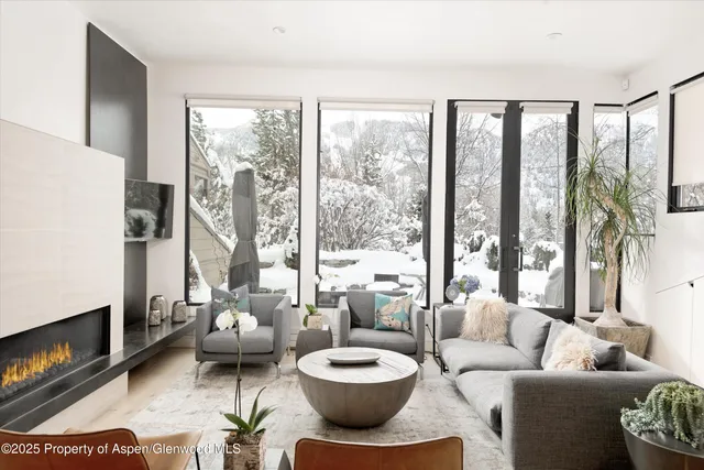a living room with furniture and a floor to ceiling window