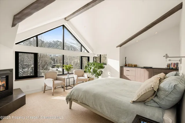 a bedroom with furniture and a large window