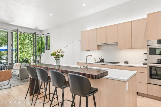 a kitchen with granite countertop a table chairs stove and cabinets