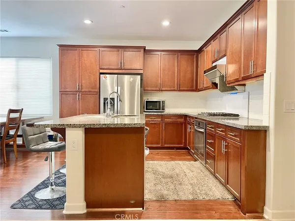 a kitchen with stainless steel appliances granite countertop a stove a sink dishwasher and a refrigerator