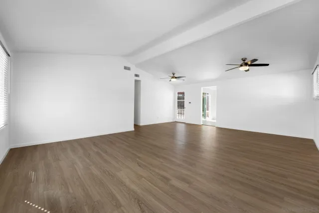 an empty room with a window and a fan