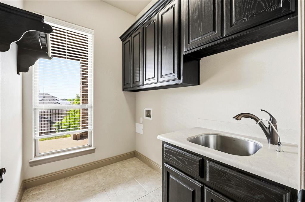 647 Gillon Way Rockwall, TX 75087 - Photo 18 of 40 Utility room includes custom cabinetry, sink and folding area.