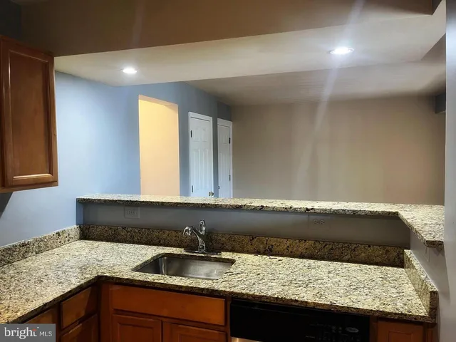 a bathroom with a granite countertop sink and a window