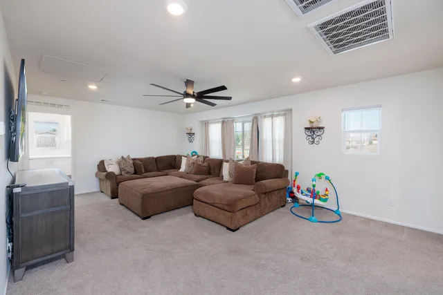 a living room with furniture and a ceiling fan