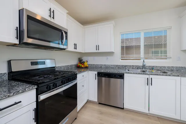 a kitchen with stainless steel appliances a refrigerator and a stove top oven