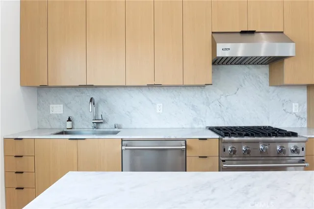 a kitchen with granite countertop a stove and a white cabinets
