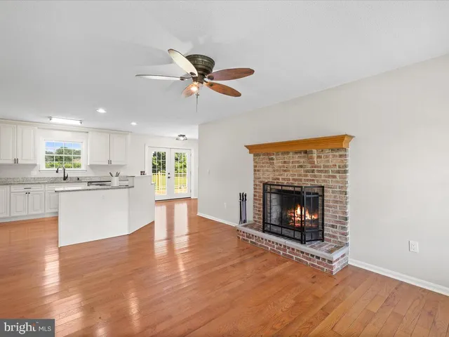 a living room with furniture a fireplace and kitchen view