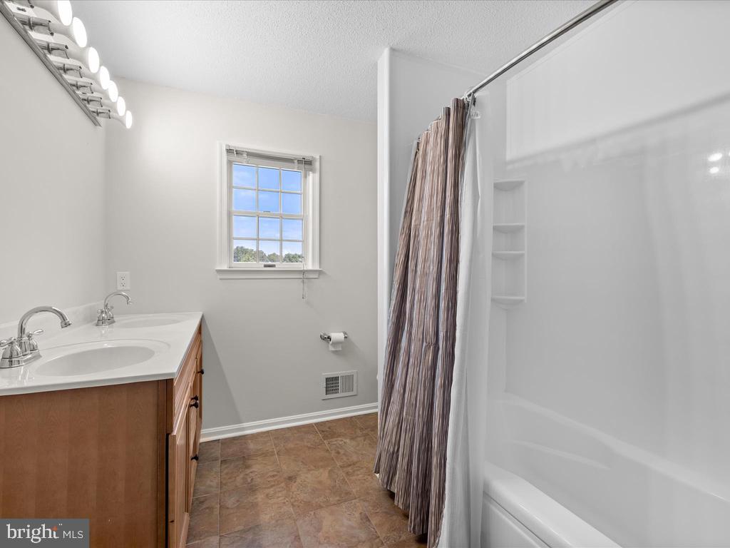 991 Church Hill Road Milford, DE 19963 - Photo 34 of 38 a bathroom with a granite countertop sink and a bathtub