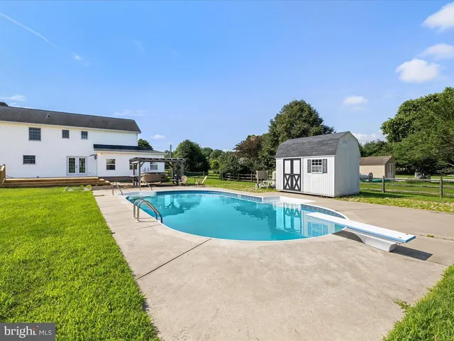 a view of a house with swimming pool and a yard