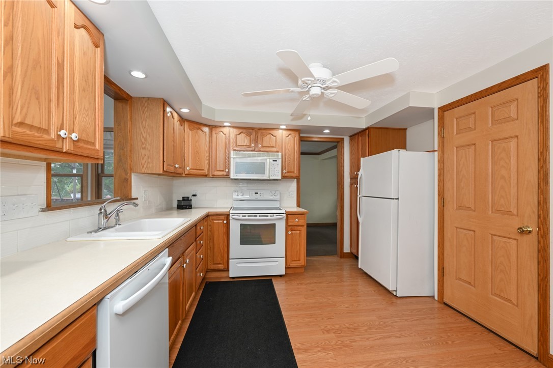 4574 Fishcreek Road Stow, OH 44224 - Photo 21 of 49 Kitchen with ceiling fan, white appliances, backsplash, light laminate / wood-style flooring, and sink