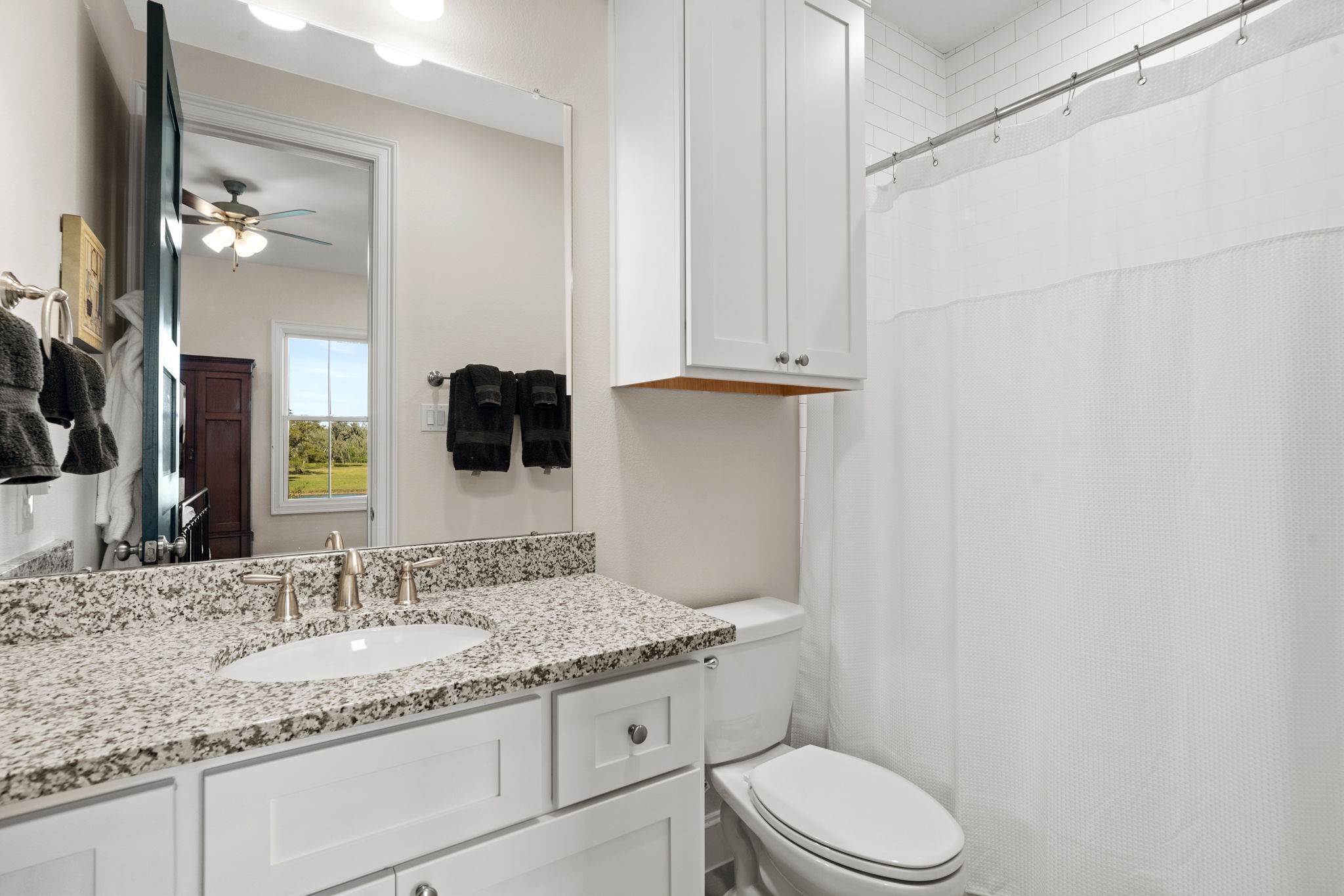 7341 County Road 27 Damon, TX 77430 - Photo 34 of 50 a bathroom with a granite countertop sink vanity mirror and toilet