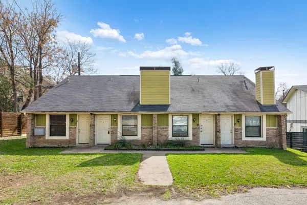 a front view of a house with a garden and yard