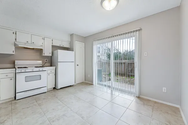 a kitchen with white cabinets and white appliances