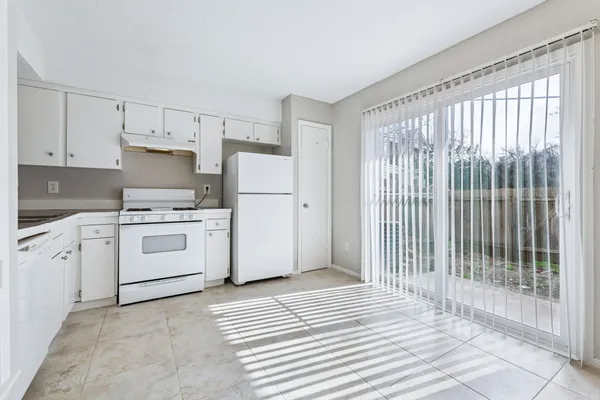a kitchen with white cabinets and white appliances