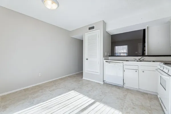 a kitchen with white cabinets and sink